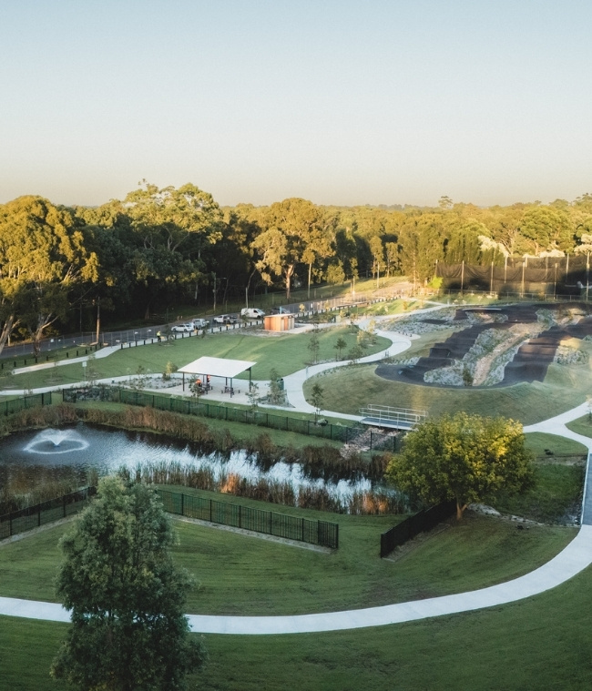 Drone image of space featuring track and pond environment
