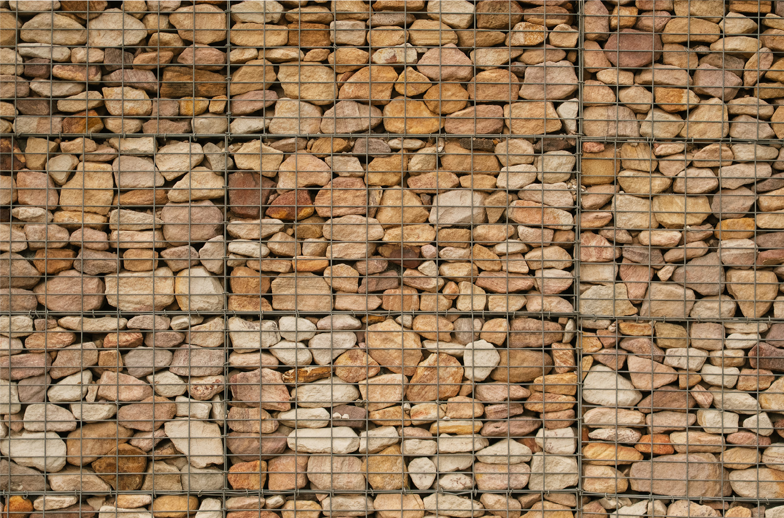 Close up shot of the gabion wall caged with rock formations inside, differing in sandstone tones