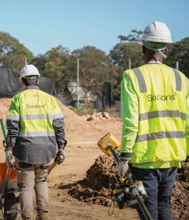 backfacing shots of staff on site with solutions+ uniform